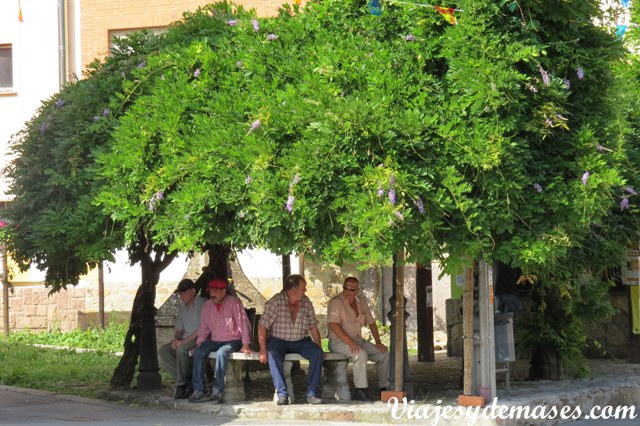 Detrás de estas personas está el quisco de información turística.